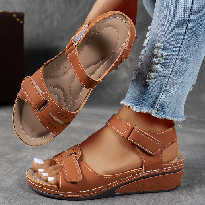 Brown orthopedic sandal with tan trim, adjustable Velcro straps, open toe, platform sole.
