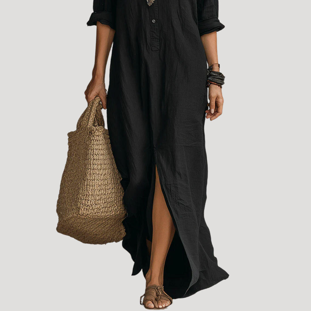 Black maxi shirt dress with side slit and curved hem, worn with woven tote
