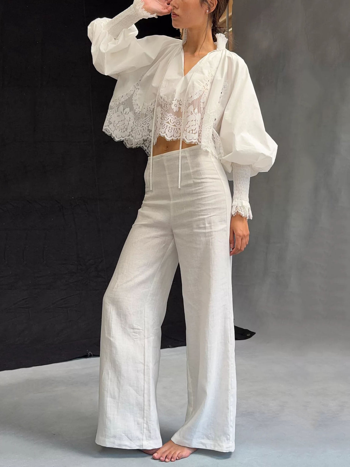 White lace blouse with V-neck, long puff sleeves, and embroidered lace center panel