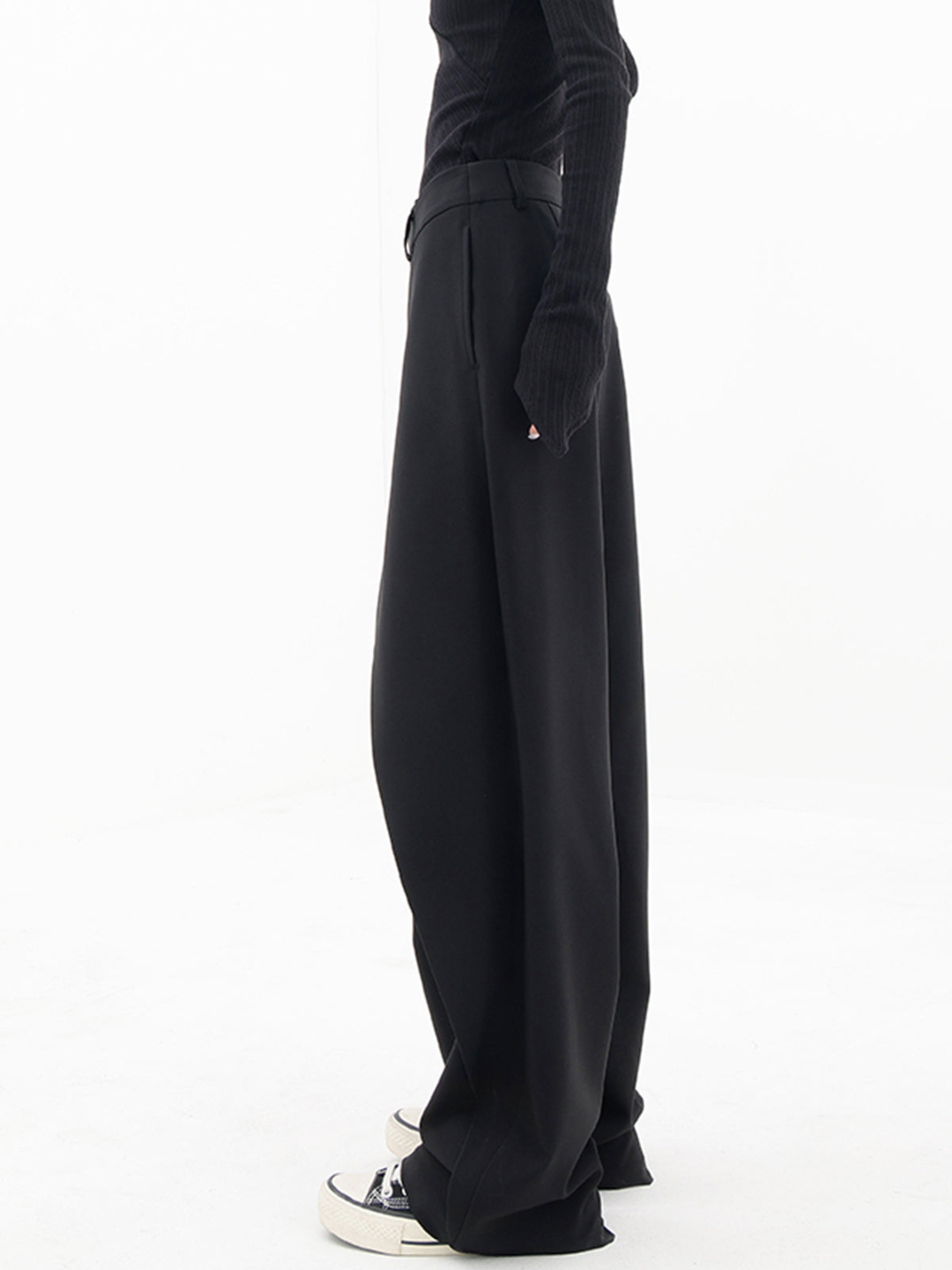 Black baggy trousers side view with long wide leg and deep front drape