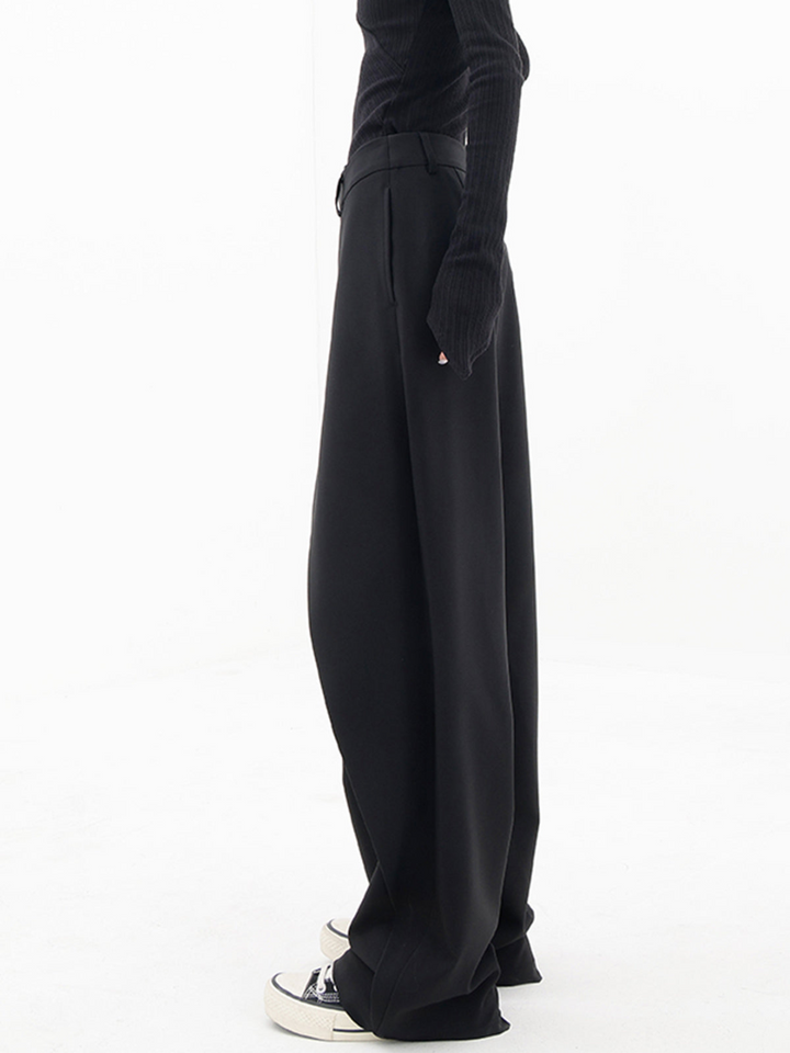 Black baggy trousers side view with long wide leg and deep front drape