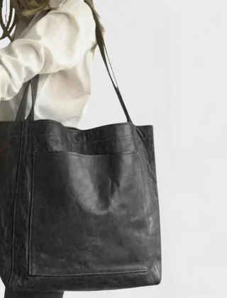 Black leather tote bag with double handles and front pocket seam