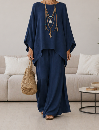 Navy two-piece set with draped tunic top and wide-leg pants, long sleeves.