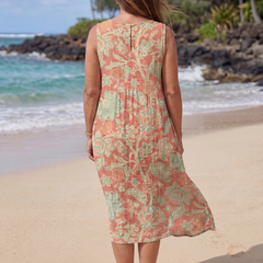 Back view of floral beach midi dress in coral and green, sleeveless with tiered hem