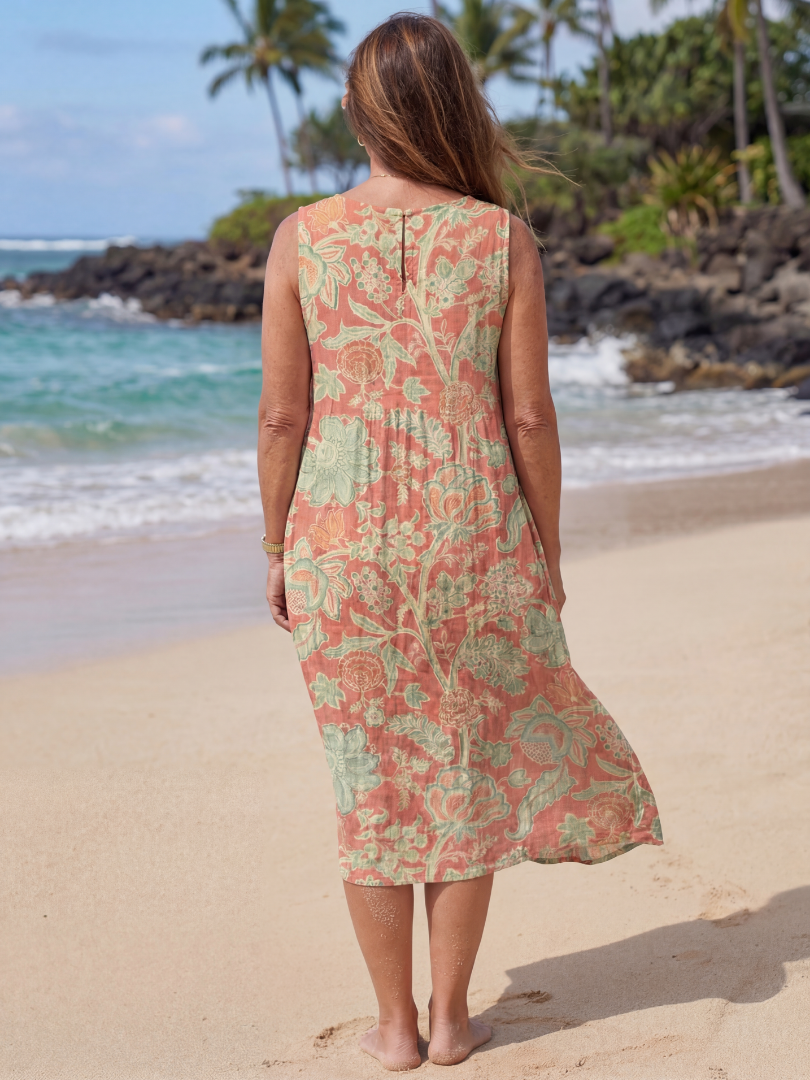 Back view of floral beach midi dress in coral and green, sleeveless with tiered hem