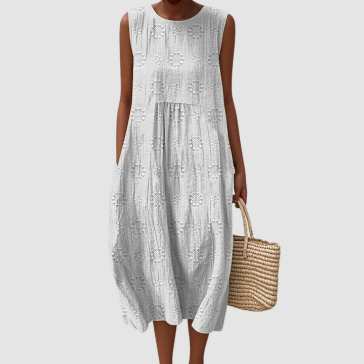 White sleeveless midi dress with embroidered eyelet clover pattern, tiered skirt