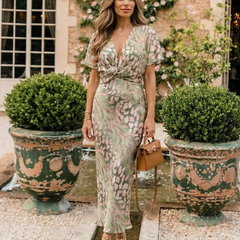 Green and blush abstract print midi dress with V-neck twist waist, flowing skirt.