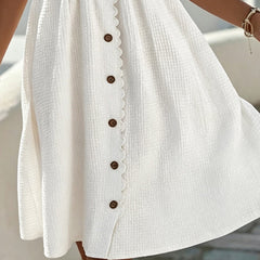 White midi dress close-up: textured fabric and center button placket