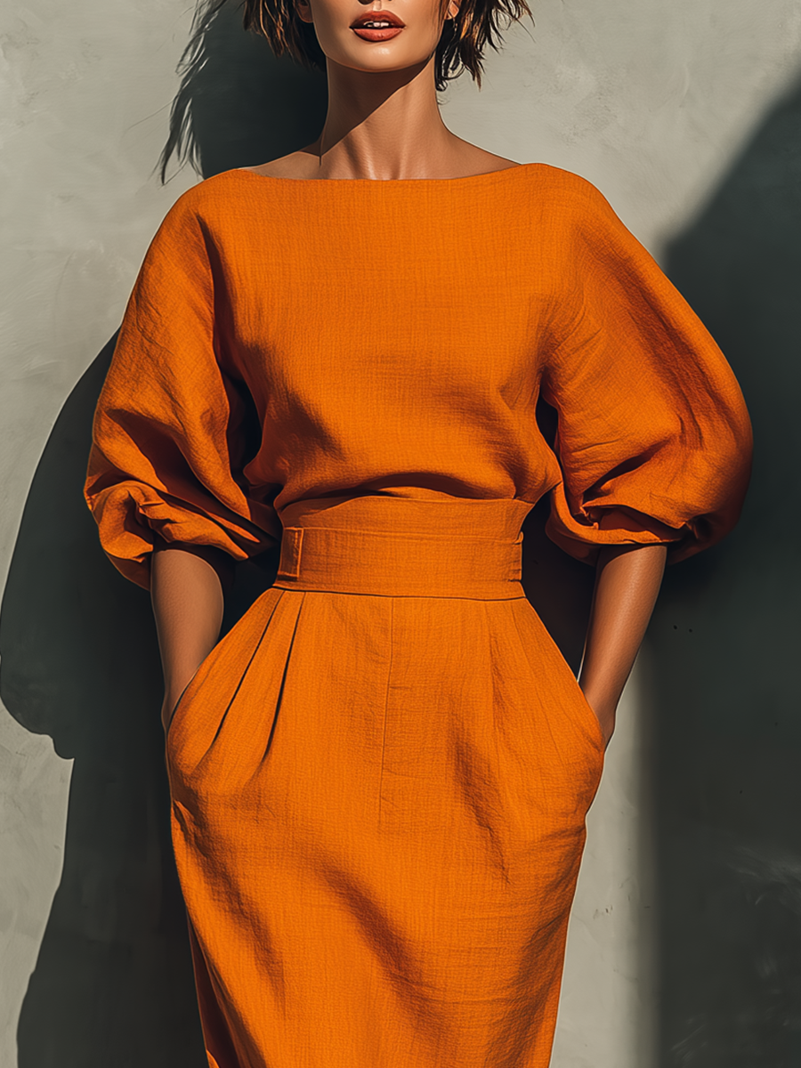 Orange skirt set with boat neckline, puff sleeves, and belted fitted midi pencil skirt