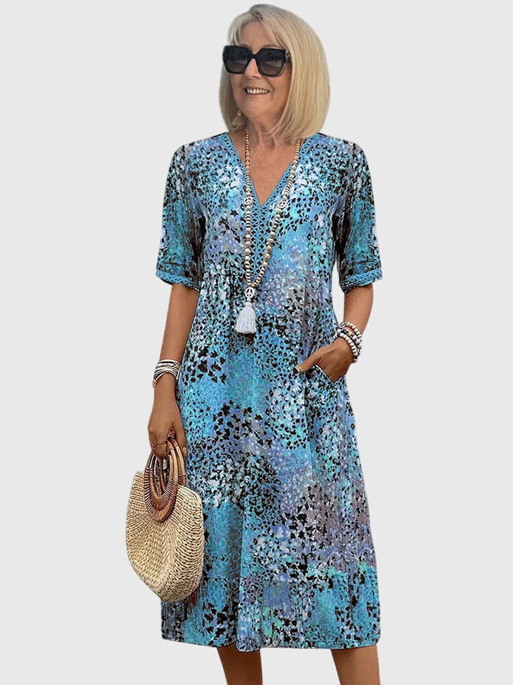 Ocean blue floral midi dress with V-neck, short sleeves, and white tassel detail