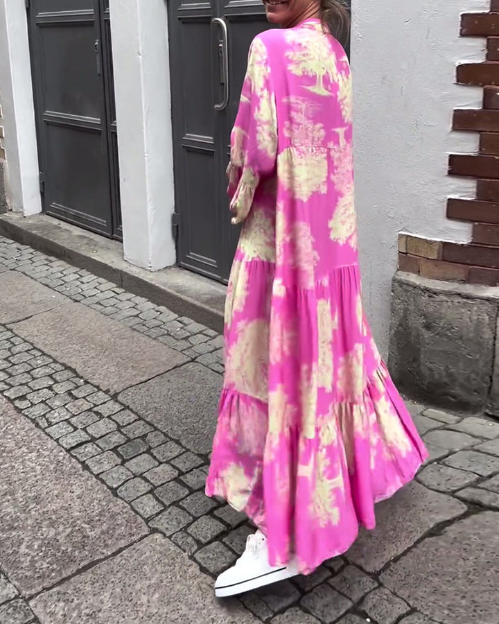 Pink long-sleeve maxi dress with cream abstract blotches, tiered skirt, button-front V neck.