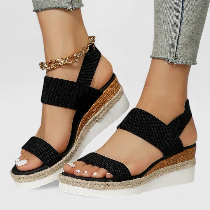 Orthopedic sandals with black wide straps and textured footbed, gold chain ankle bracelet