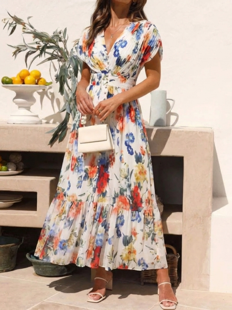 Floral pleated midi dress with short sleeves and V-neck; model holding a white bag
