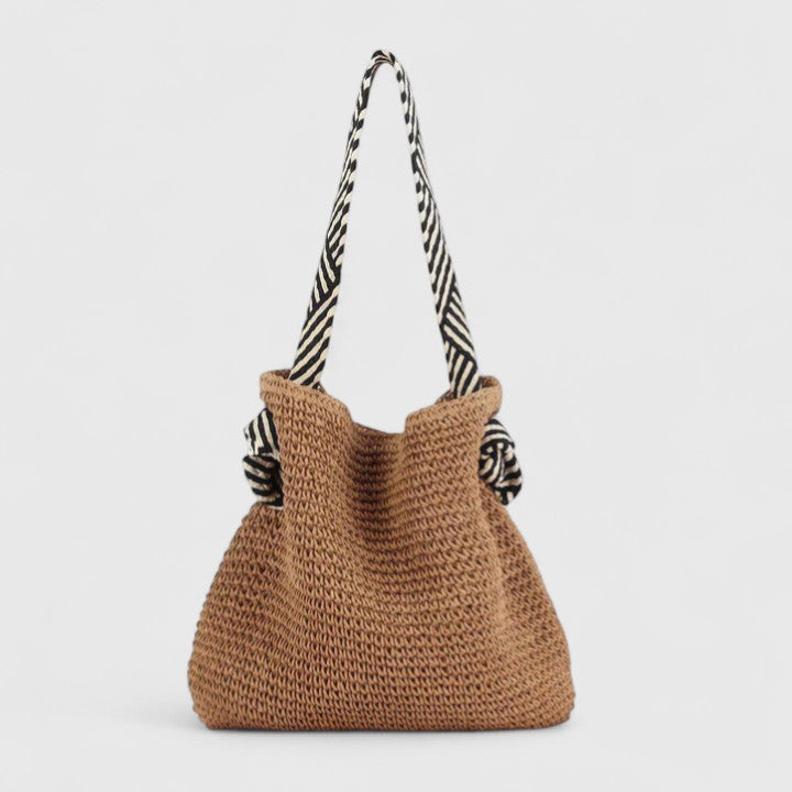 Warm brown woven boho tote bag with two black-and-white striped fabric handles