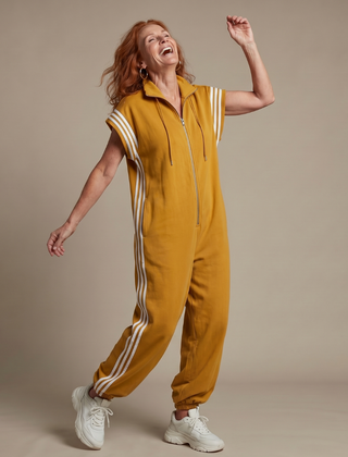 Mustard yellow zip-front jumpsuit with white striped sleeves and drawstring hood