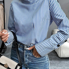 Blue-and-white striped high-neck long-sleeve top with buttoned cuffs, angled view.