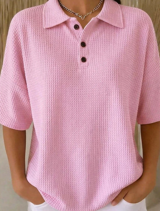 Pink waffle knit polo blouse with short sleeves, pointed collar, three-button placket