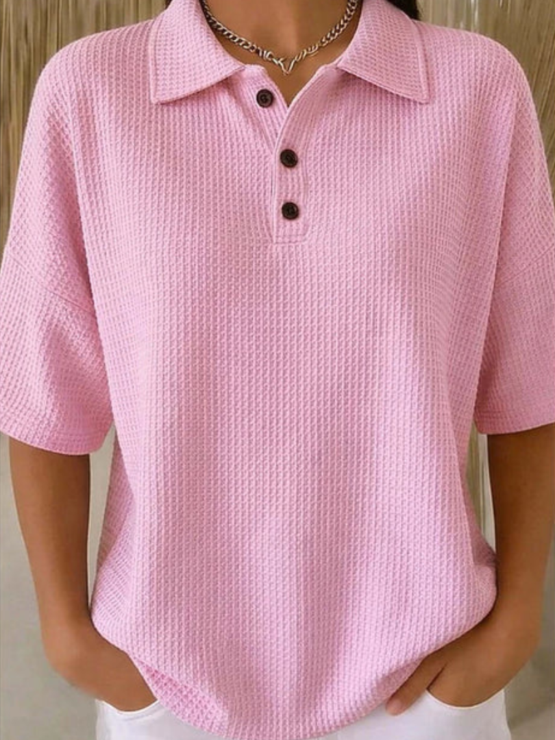 Pink waffle knit polo blouse with short sleeves, pointed collar, three-button placket