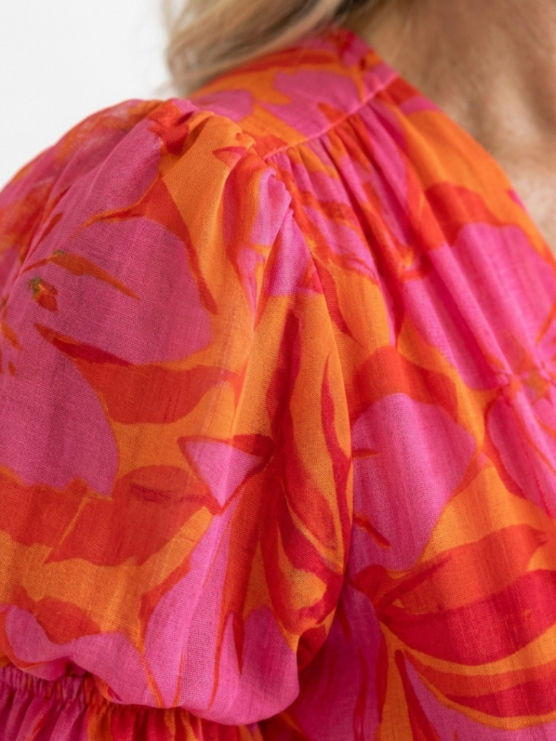 Pink floral puff sleeve detail with gathered neckline and billowy ruffles