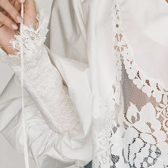 White lace blouse close-up with scalloped embroidery and drawstring ties at the hem