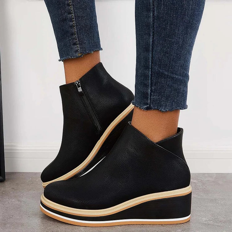 Black ankle boots with side zipper and tan-trimmed platform soles