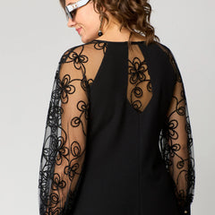 Black dress back view with sheer lace long sleeves and lace-covered shoulders.