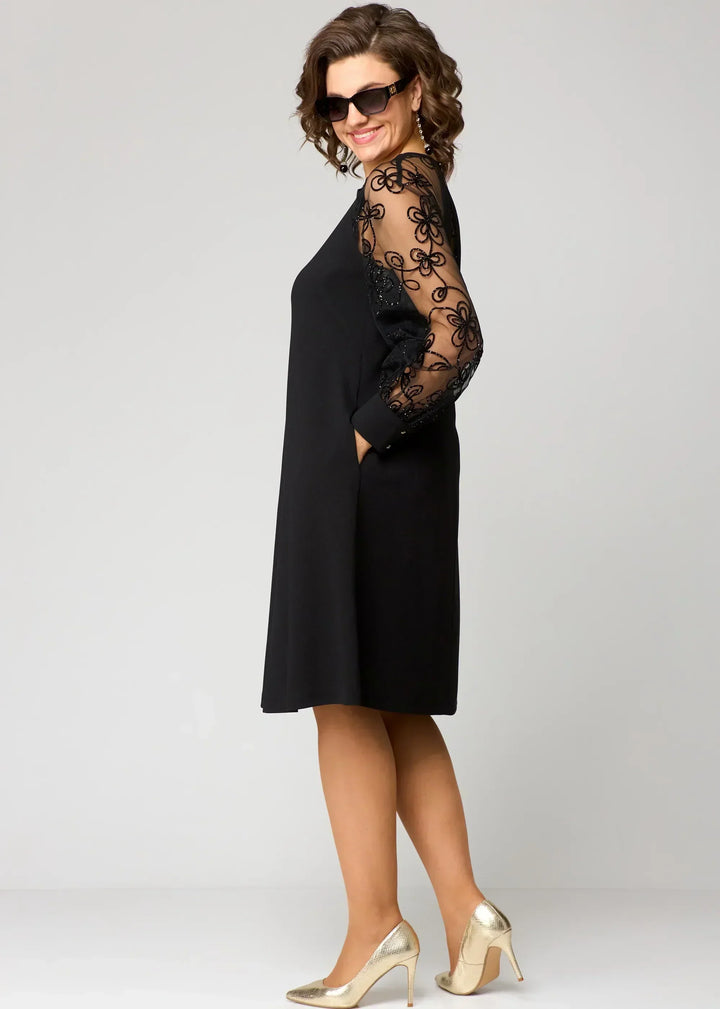 Black midi dress with lace sleeves and round neckline, side profile