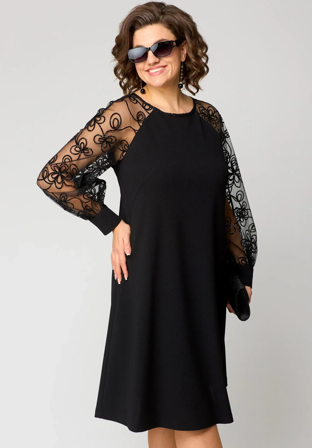 Black midi dress with sheer lace sleeves and round neckline; fitted waist.