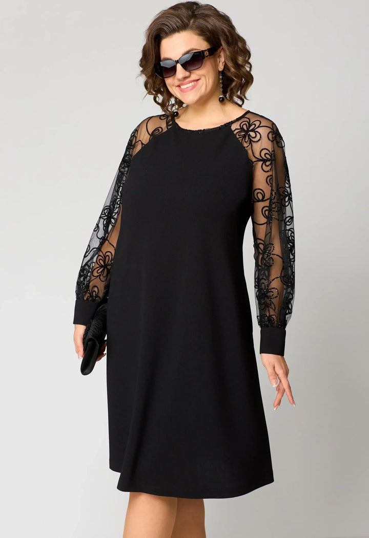 Black A-line dress with sheer lace sleeves and embroidered lace overlay on arms.