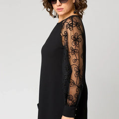 Black A-line dress with sheer lace panel sleeve and long sleeves.