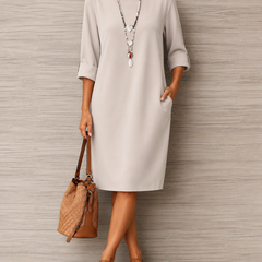 Off-white midi dress with round neckline, 3/4 sleeves, and relaxed straight fit
