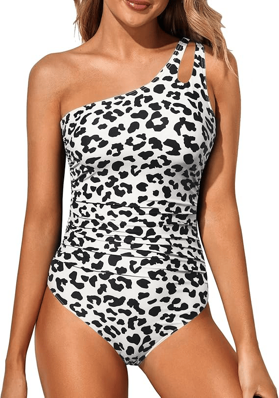One-shoulder swimsuit in white with black leopard print, ruched front.