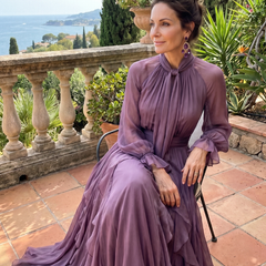 Purple tie-neck tiered maxi dress with ruffled skirt and long sheer sleeves, front