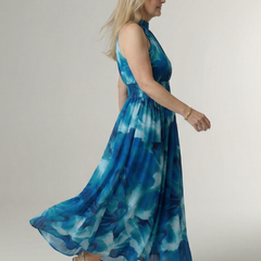 Blue tie-dye halter midi dress, side view with gathered waist and flowing skirt