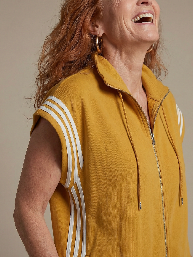 Mustard yellow zip-front jumpsuit with white stripe trim and drawstring hood