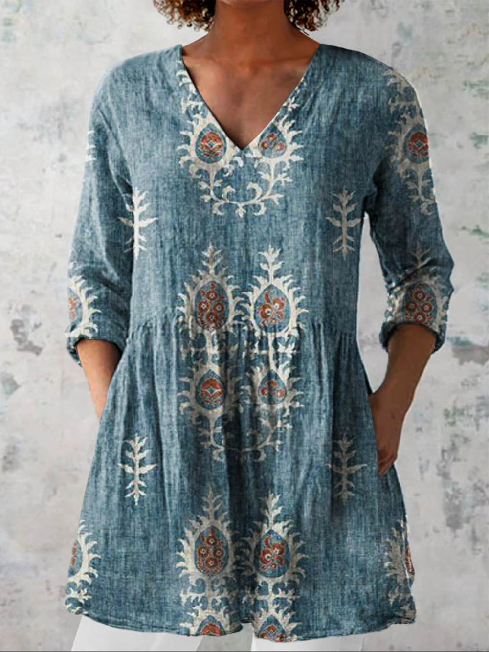 Blue long-sleeve V-neck embroidered blouse with gathered waist and ornate folk motifs
