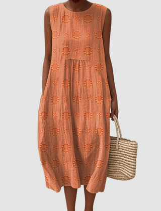 Orange sleeveless midi dress with embroidered eyelet clover pattern, tiered skirt