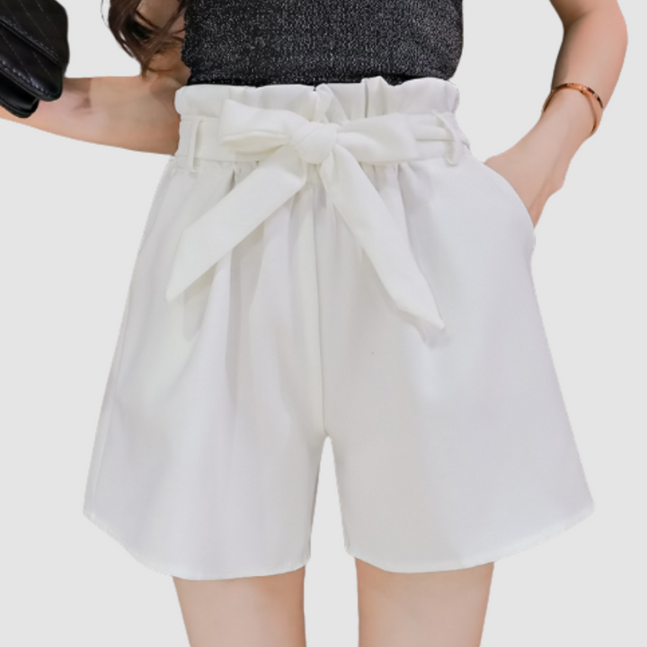 White paperbag waist shorts with tied bow and pleated elastic waistband.