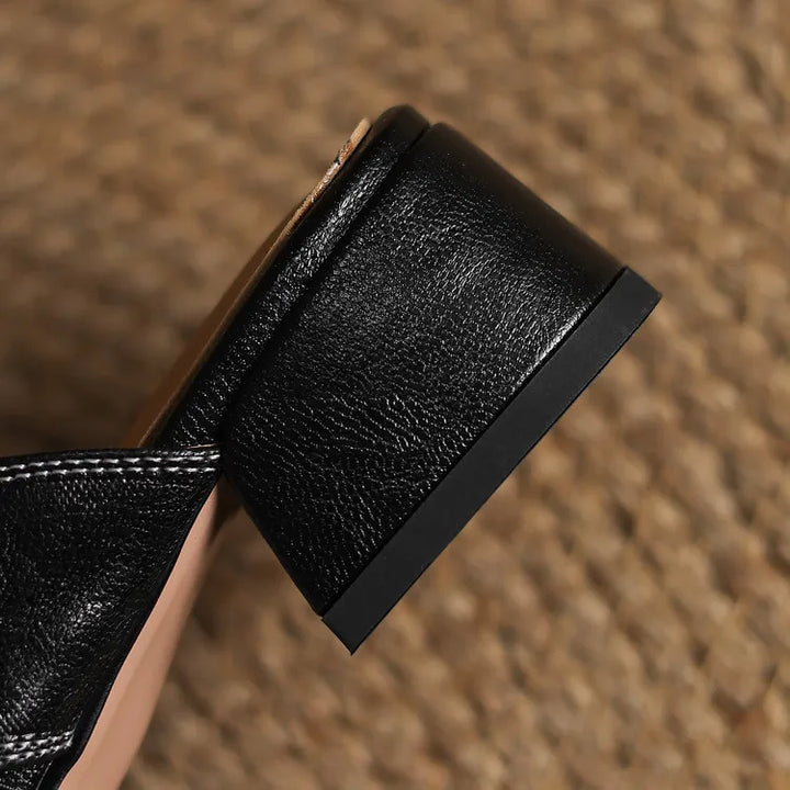Black leather mule heel and strap detail with textured finish