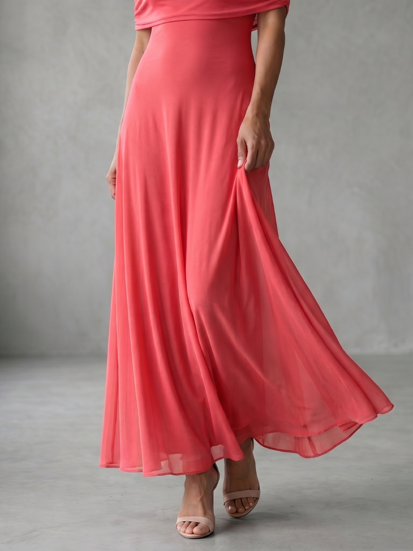 Off-shoulder draped midi dress in coral pink, close-up of flowing skirt hem
