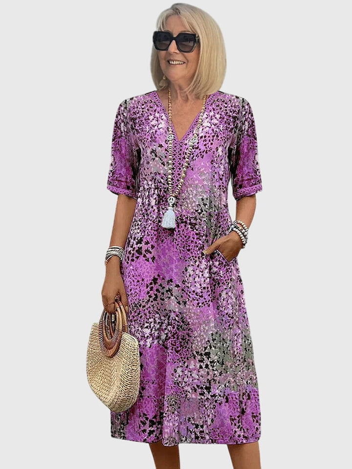 Lavender purple floral midi dress with V-neck, short sleeves, and white tassel detail