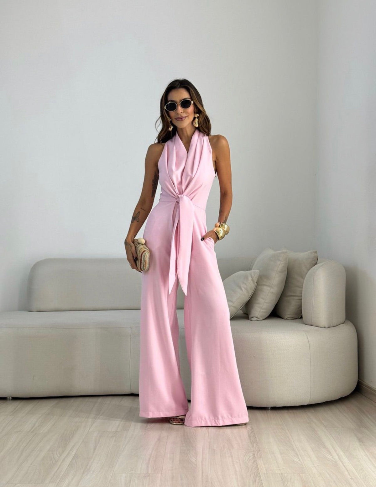 Pink sleeveless jumpsuit with wrap V-neck and tied waist, wide-leg