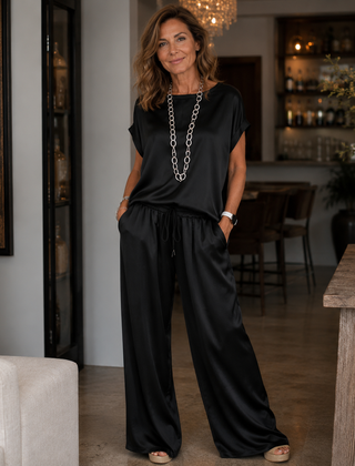 Black satin two-piece set with short-sleeve top and drawstring wide-leg pants