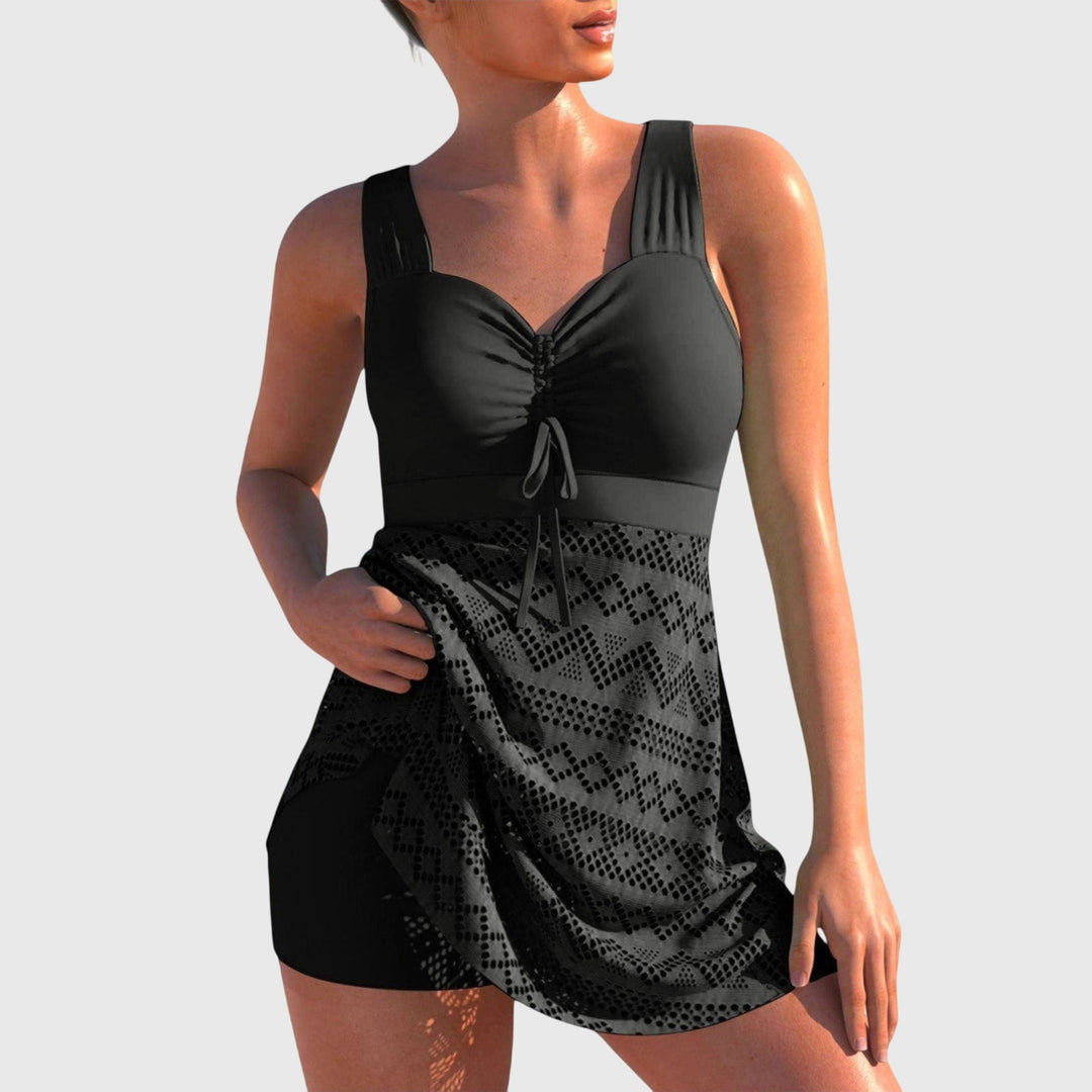 Black padded two-piece swimsuit with ruched tie-front bra and geometric skirt overlay.