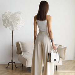 Cream wide-leg trousers shown from the back, high waist with tied sash belt
