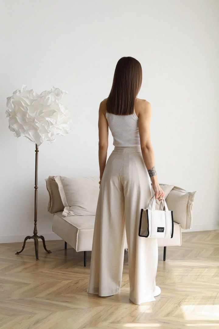 Cream wide-leg trousers shown from the back, high waist with tied sash belt
