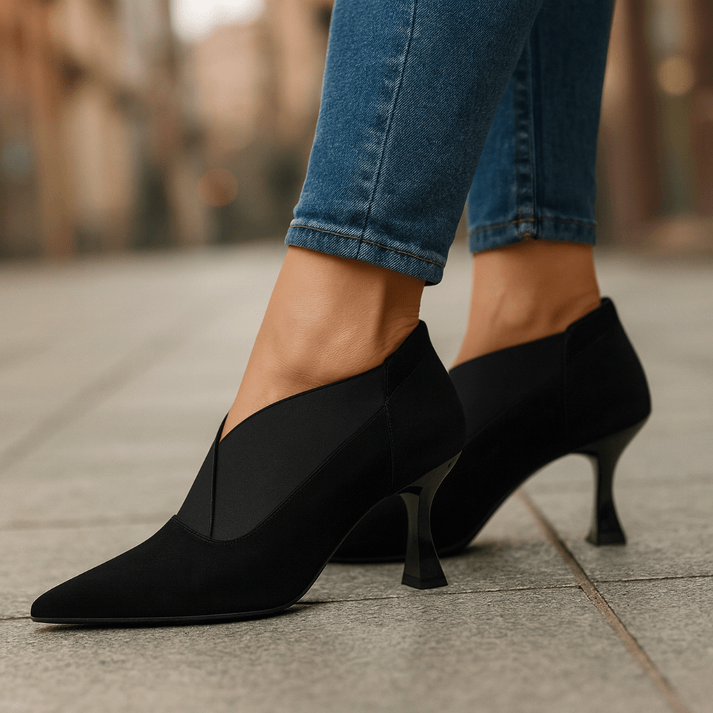 Black suede pointed-toe heeled pumps with slim heel and curved side seam