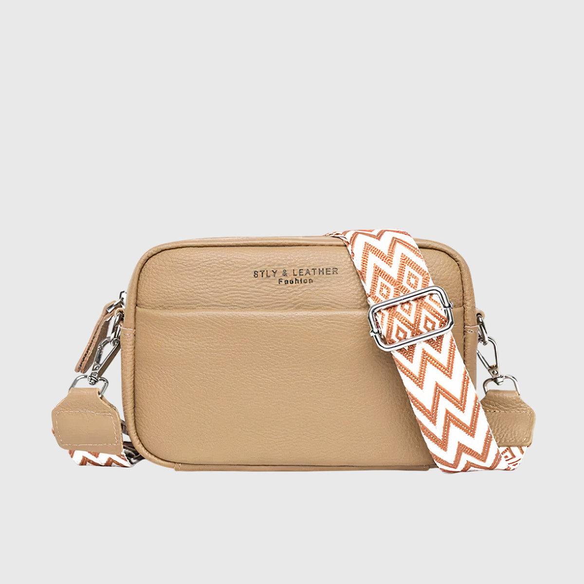 Tan leather shoulder bag with patterned chevron strap and silver-tone zipper pulls