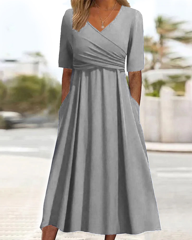 Gray crossover dress with short sleeves, V-neck, gathered waist, and A-line skirt.