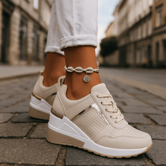 Beige lace-up sneakers with perforated toe and cushioned white sole.